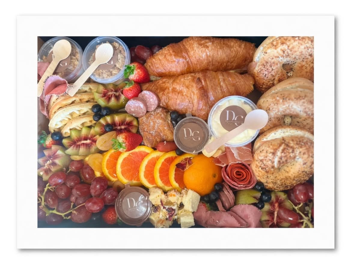 Breakfast platter with croissants, pastries, grapes and yoghurt cups